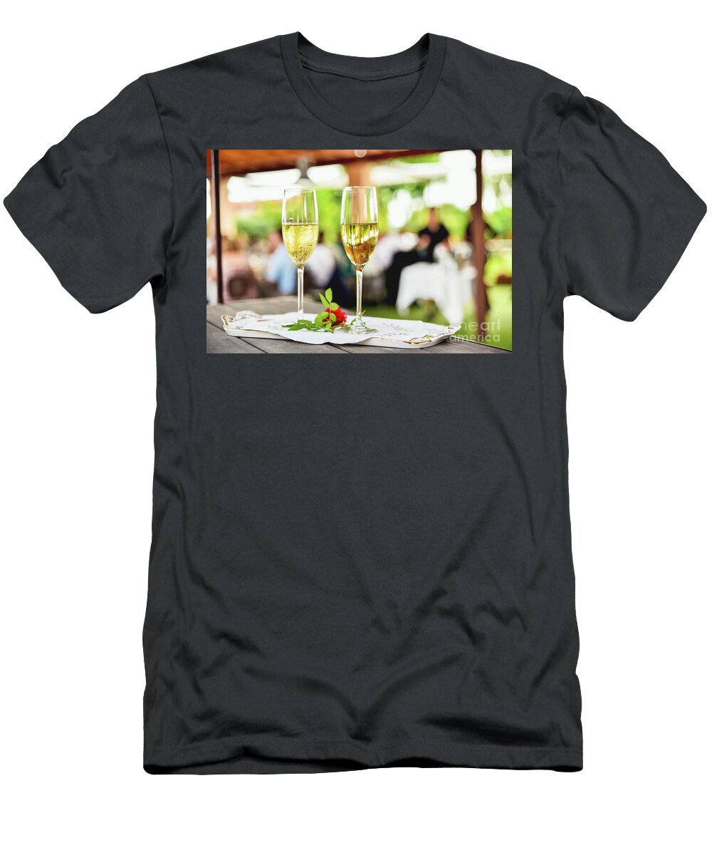 Two Glasses of Bubbly Champagne with Unfocused Background of a C Joaquin Corbalan T-Shirt